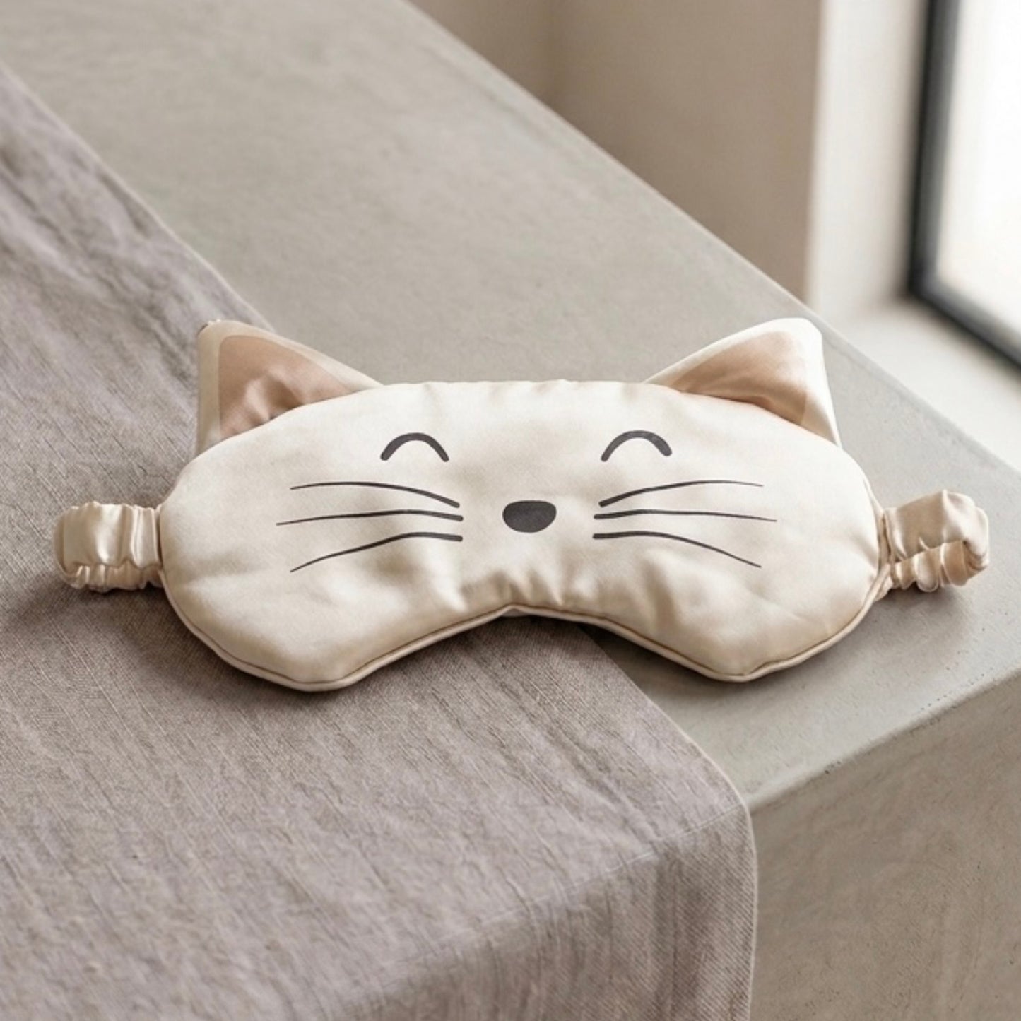 Cat-shaped eye mask on a surface with a neutral background