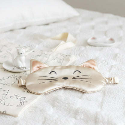 Cat satin sleep mask laid on a bed, ready for a nap