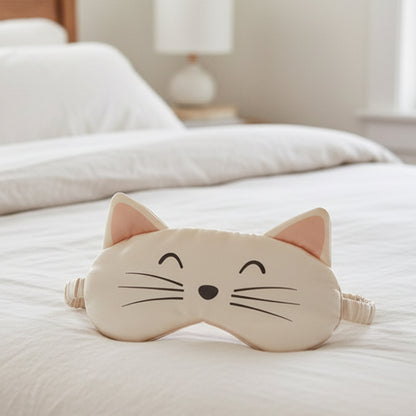 Cat-shaped sleep mask on a bed in a bedroom setting. Cat eye mask as a travel companion for sleeping on a plane.